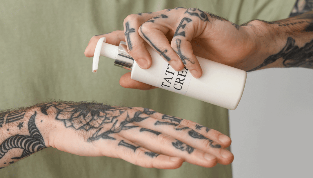 Person trägt Pflegeprodukt auf frisch gestochenes Tattoo auf